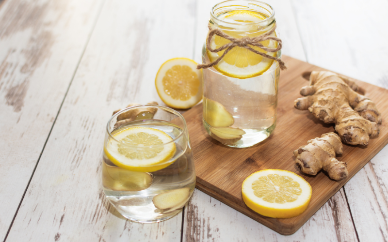 Acqua e zenzero con limone in barattoli di vetro e radice fresca